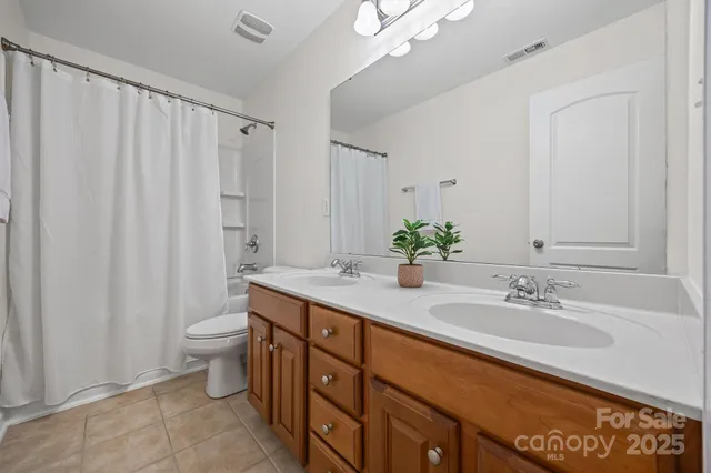 a bathroom with a granite countertop sink a toilet and a mirror