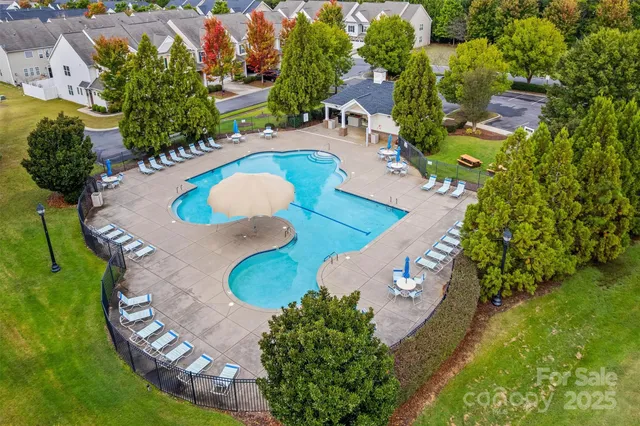 an aerial view of a house with a yard and swimming pool
