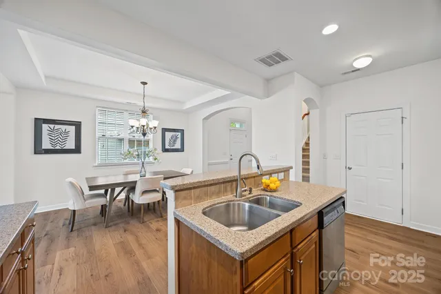 a kitchen with a table chairs sink and wooden floor