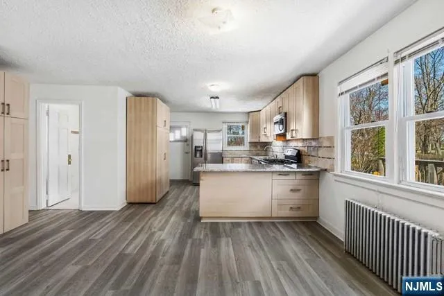 a kitchen with a refrigerator and wooden cabinets