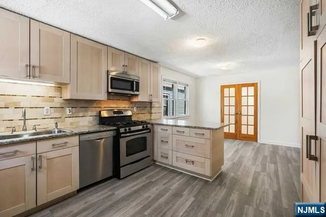 a kitchen with granite countertop a stove top oven sink and cabinets