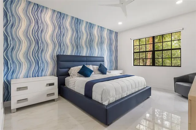 a spacious bedroom with a bed and a dresser