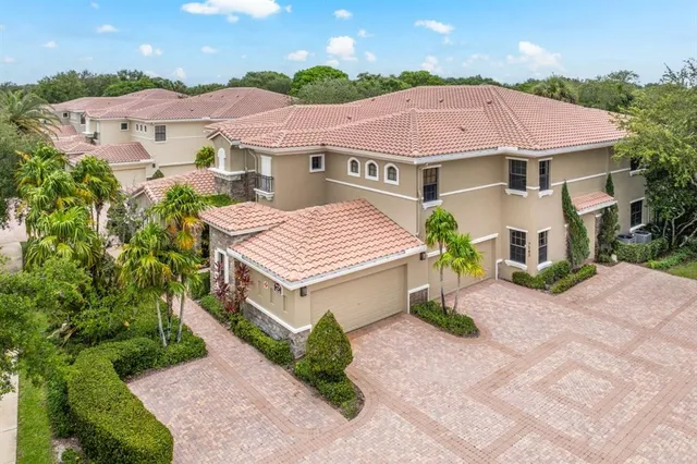 a view of a house with a yard and potted plants