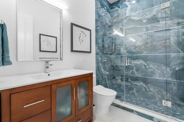 a bathroom with a sink a toilet and shower