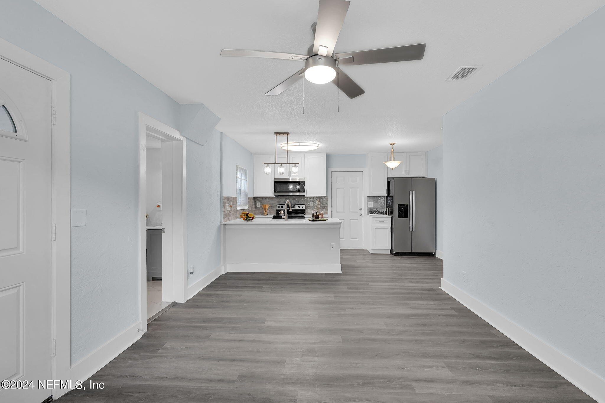 6763 Ector Road Jacksonville, FL 32211 - Photo 13 of 28 a view of kitchen with kitchen island white cabinets stainless steel appliances and wooden floor