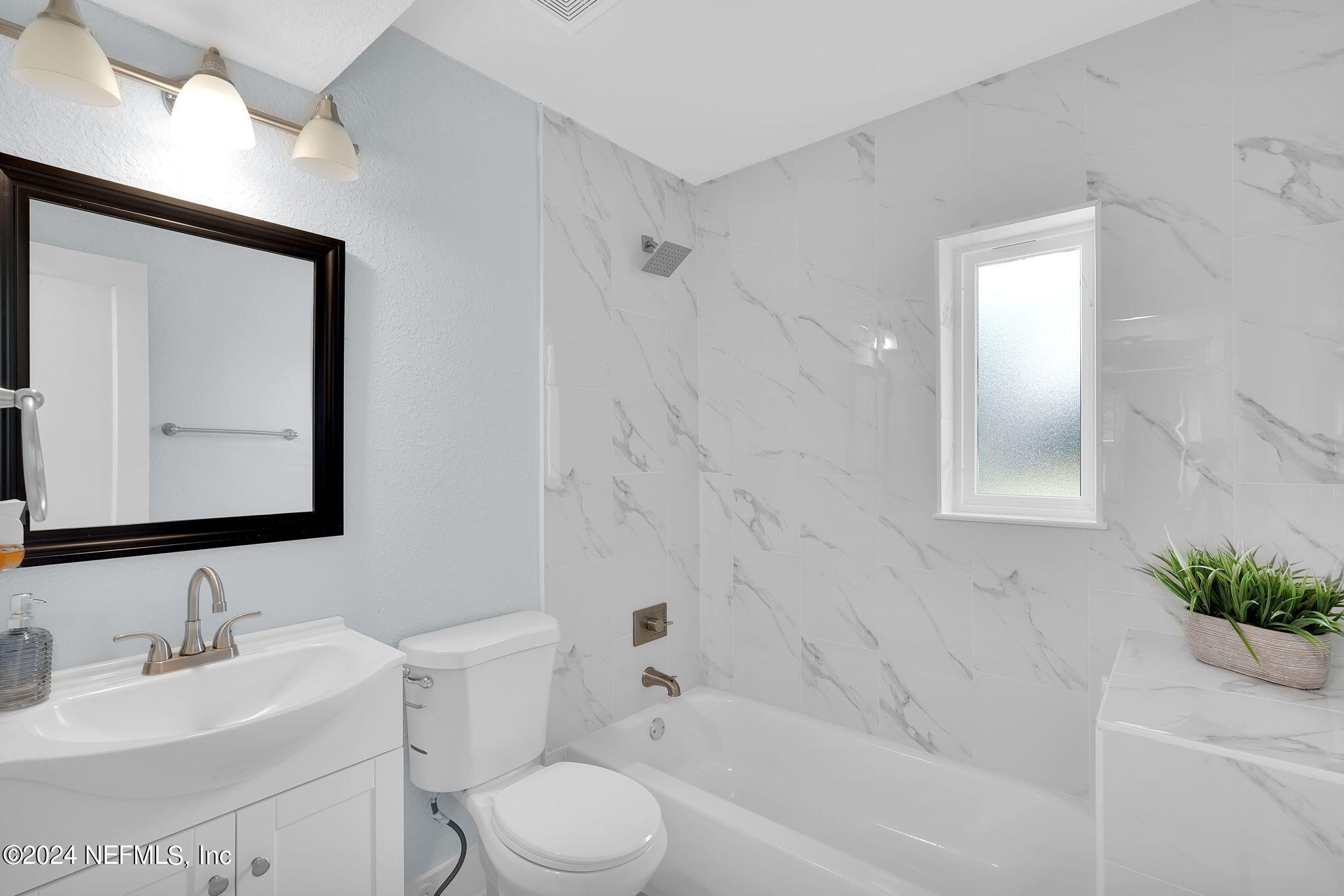 6763 Ector Road Jacksonville, FL 32211 - Photo 19 of 28 a bathroom with a bathtub shower sink vanity mirror and toilet