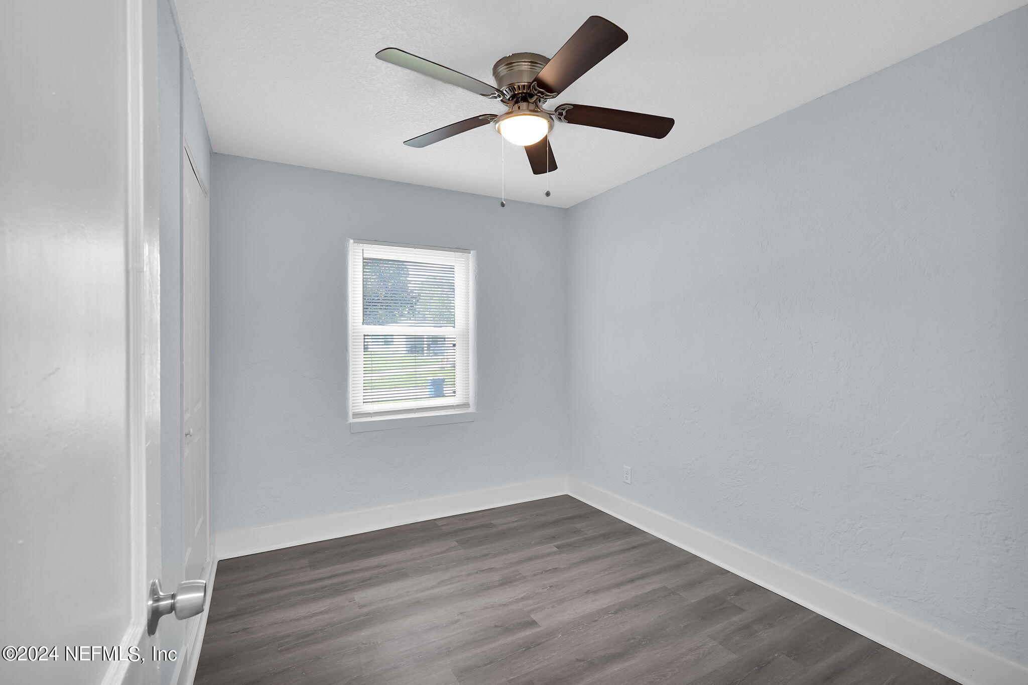 6763 Ector Road Jacksonville, FL 32211 - Photo 21 of 28 an empty room with wooden floor and ceiling fan