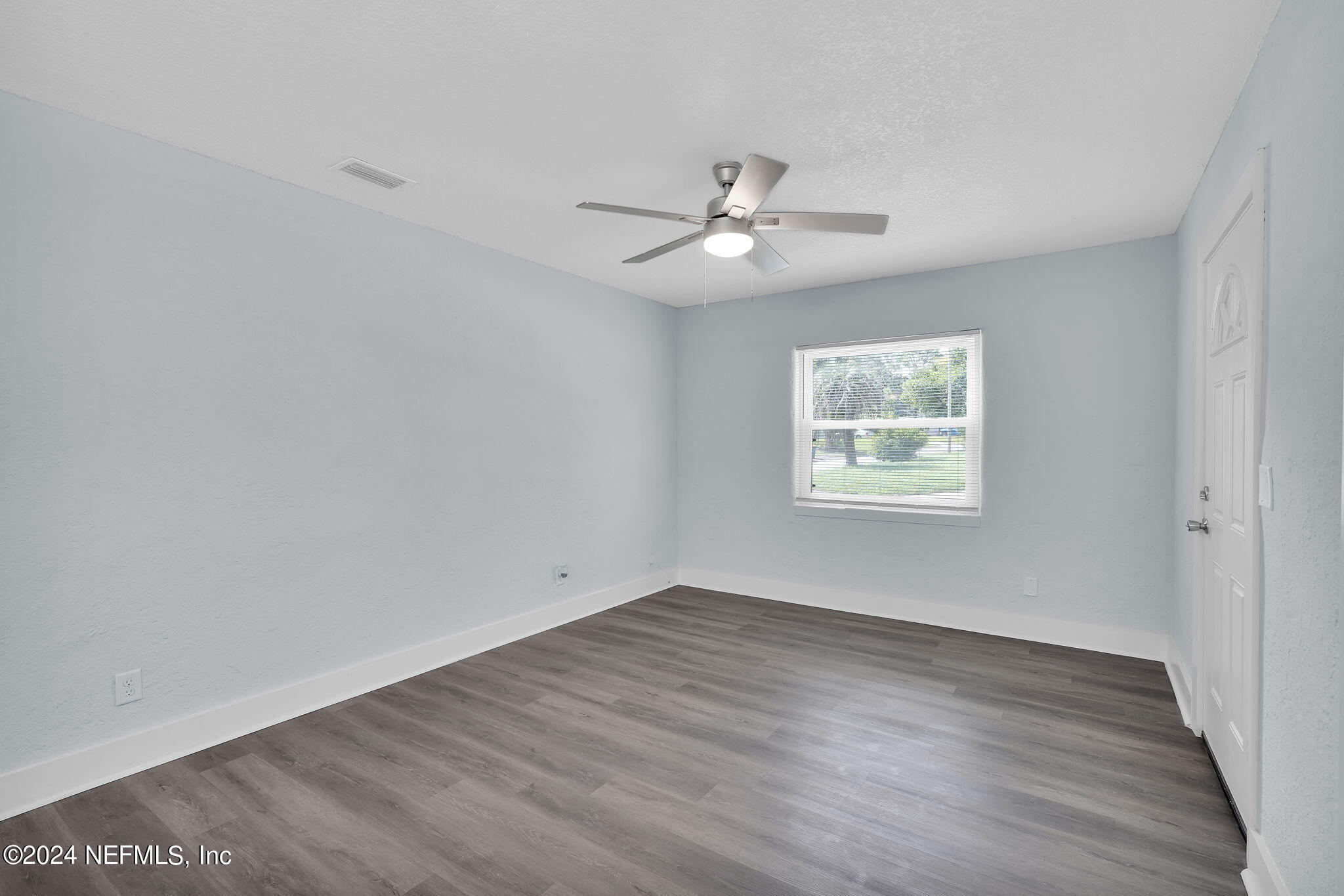 6763 Ector Road Jacksonville, FL 32211 - Photo 9 of 28 an empty room with wooden floor ceiling fan and windows