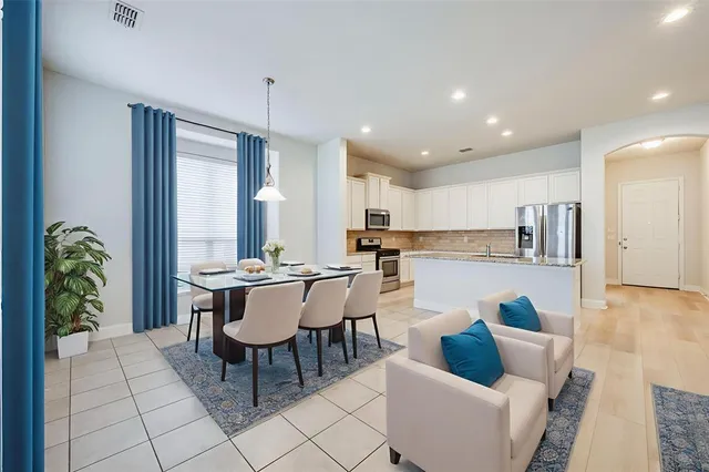 a kitchen with stainless steel appliances granite countertop a stove top oven a sink dishwasher and a refrigerator with wooden floor