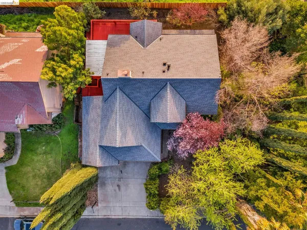 a view of a livingroom with a fireplace a ceiling fan and wooden floor