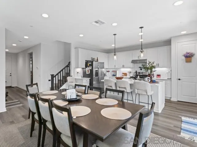 a dining room with stainless steel appliances kitchen island a table and chairs