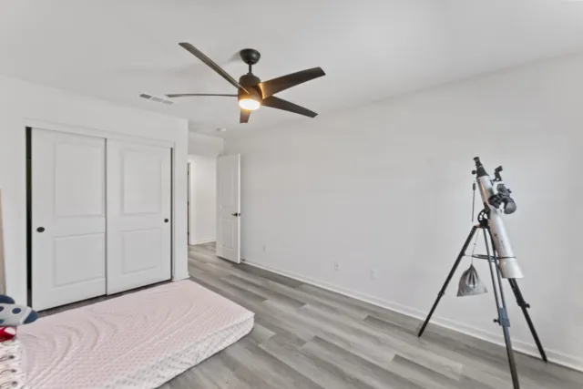 a bedroom with a bed and a ceiling fan
