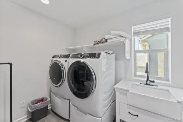 a utility room with sink dryer and washer