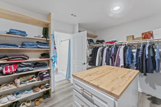 a view of walk in closet with clothes and shoes