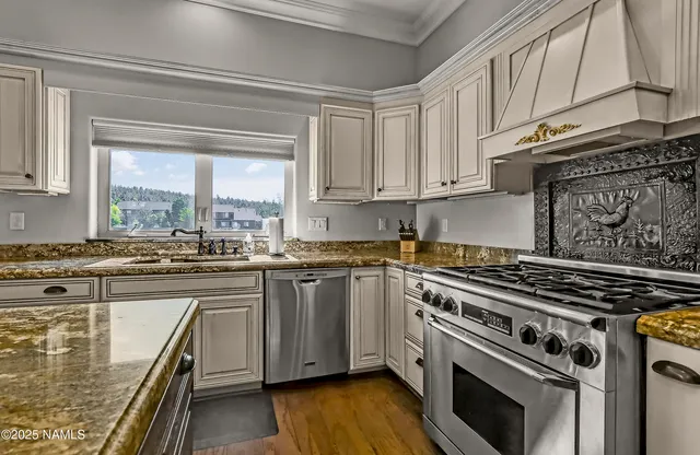 a kitchen with stainless steel appliances granite countertop a stove and a sink