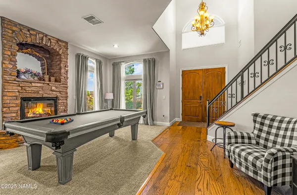 a living room with furniture pool table and a fireplace