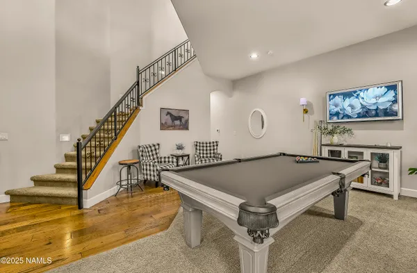 a living room with furniture pool table and windows