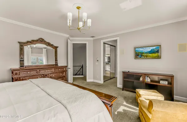 a bedroom with a bed and a chandelier