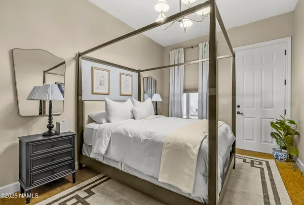 a bedroom with a bed and a painting on the wall