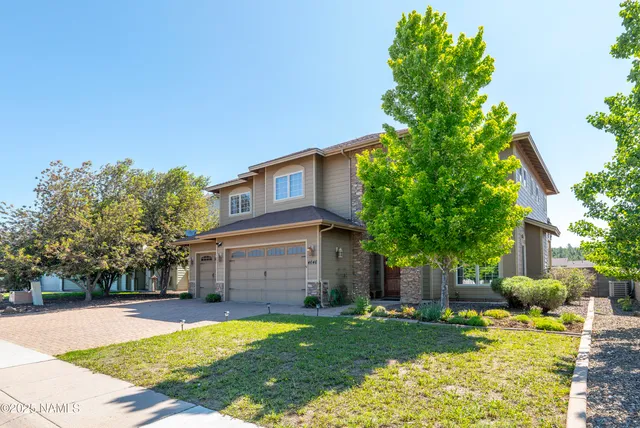 a view of a house with backyard and tree