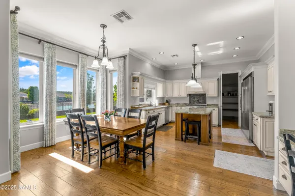 a dining area with a table chairs and kitchen view