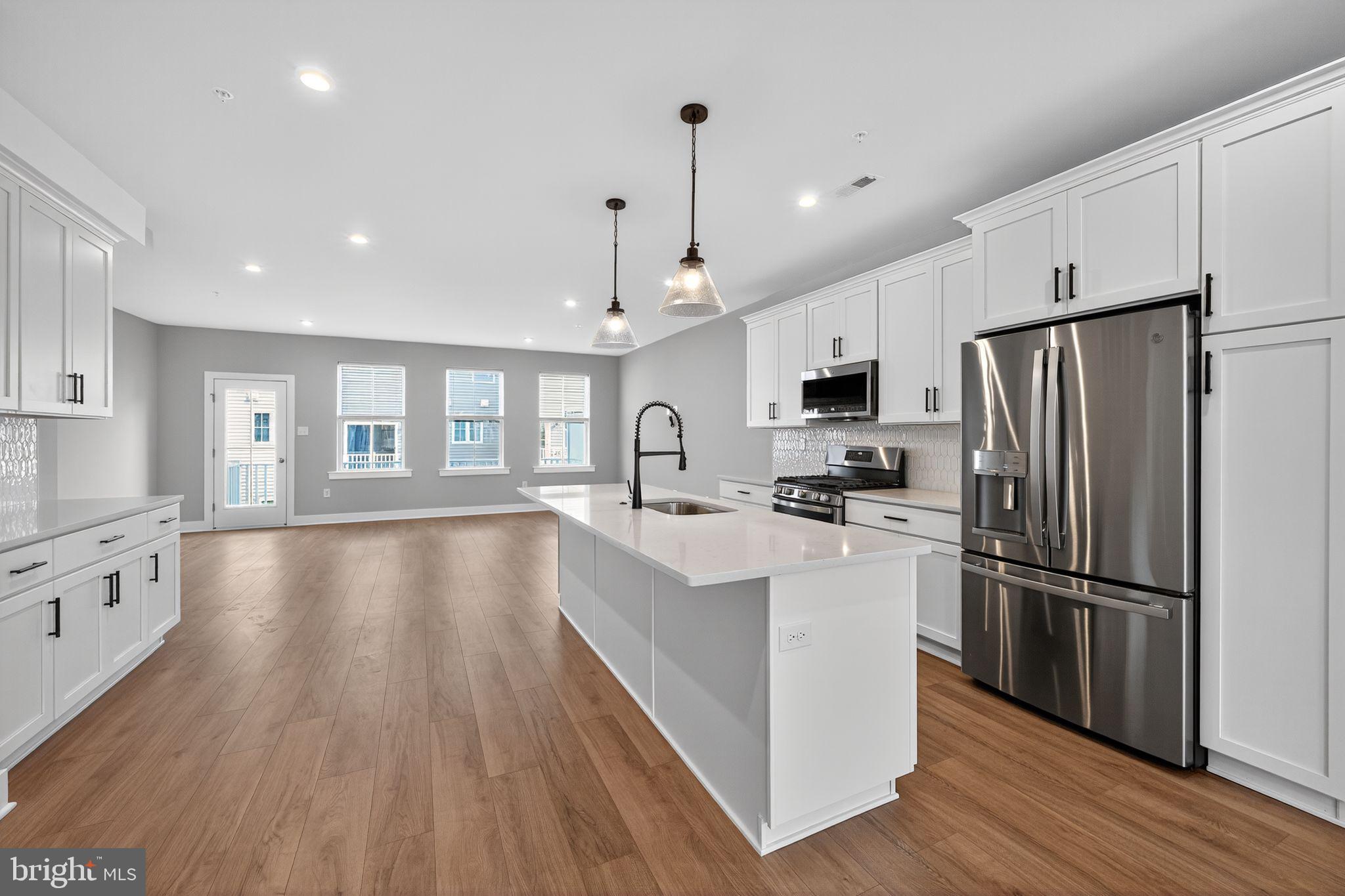 a kitchen with stainless steel appliances a refrigerator sink and cabinets