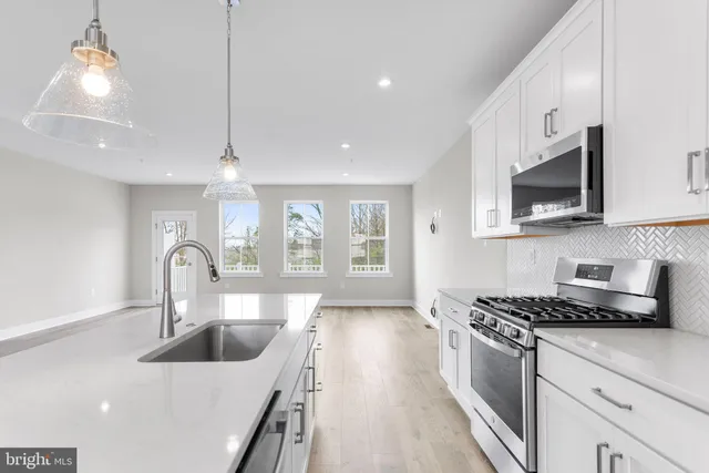 a kitchen with kitchen island a sink appliances and cabinets