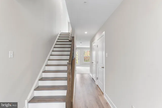 a view of a hallway with wooden floor and entryway