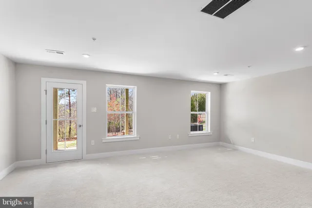 an empty room with windows and cabinet