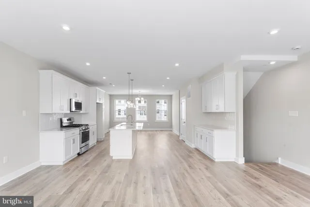 a open kitchen with white cabinets and stainless steel appliances