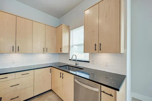 a kitchen with stainless steel appliances granite countertop a refrigerator a sink and a stove