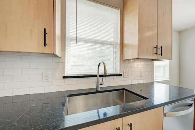 a kitchen with granite countertop white cabinets and sink