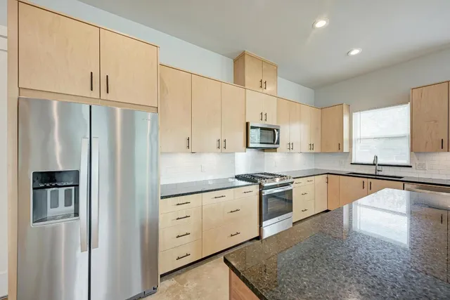 a kitchen with granite countertop white cabinets and white appliances