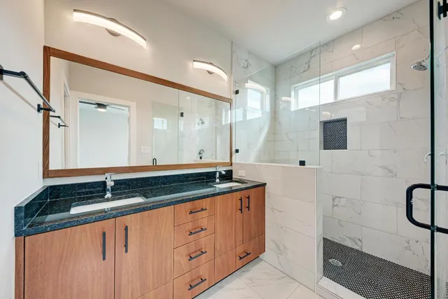 a view of an empty room with wooden floor and a ceiling fan