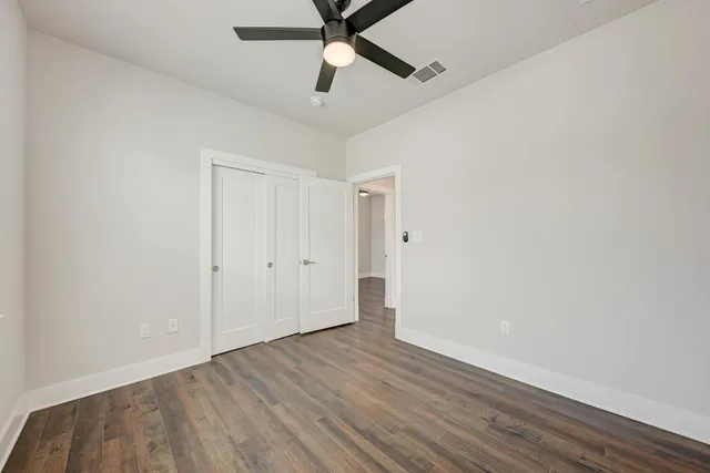 a view of a room with wooden floor and a ceiling fan
