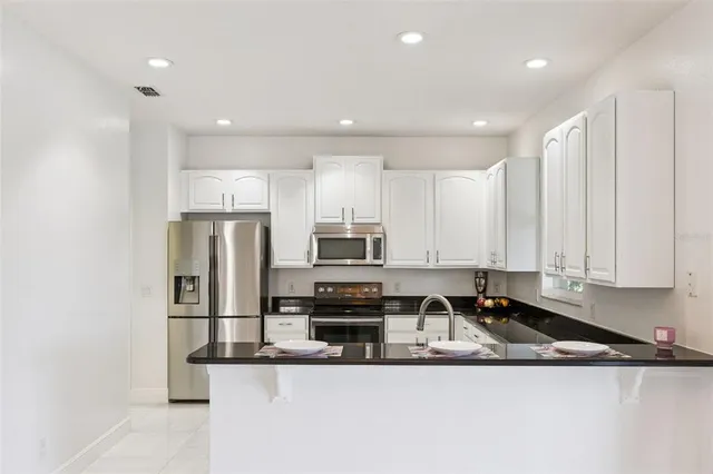 a kitchen with stainless steel appliances granite countertop a refrigerator and a stove