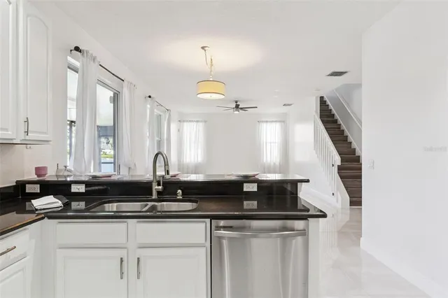 a view of a kitchen with a sink and chandelier