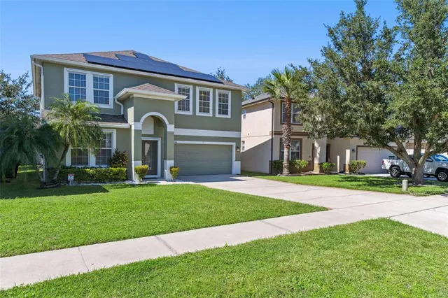 a front view of a house with a yard and trees