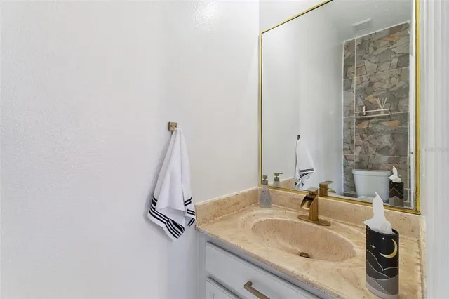 a bathroom with a granite countertop sink and a mirror