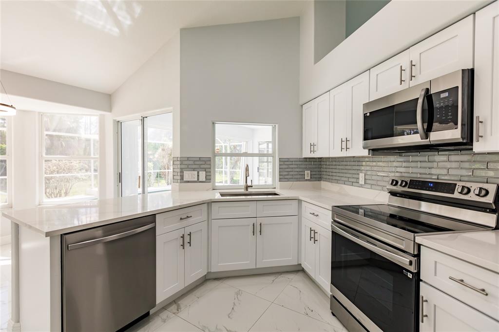 1304 Islamorada Boulevard Punta Gorda, FL 33955 - Photo 11 of 45 a kitchen with stainless steel appliances white cabinets a sink and a stove