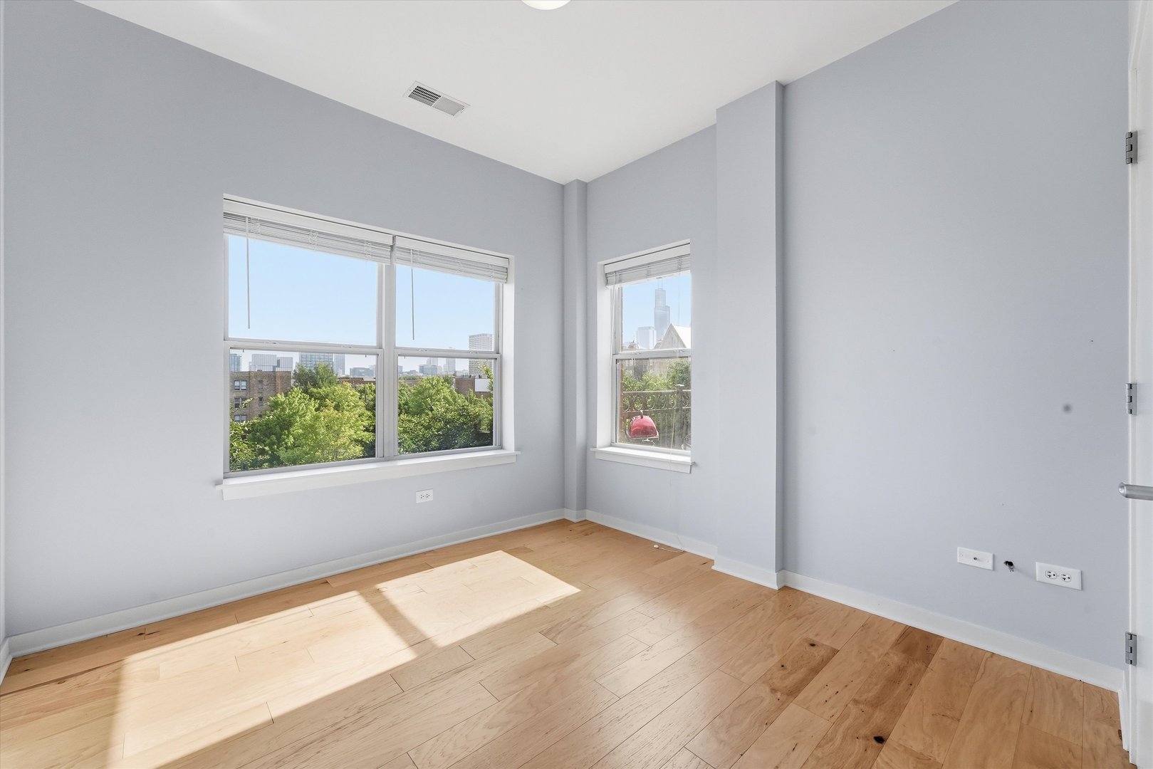 1155 West Roosevelt Road, Unit 404 Chicago, IL 60608 - Photo 20 of 30 an empty room with wooden floor and windows