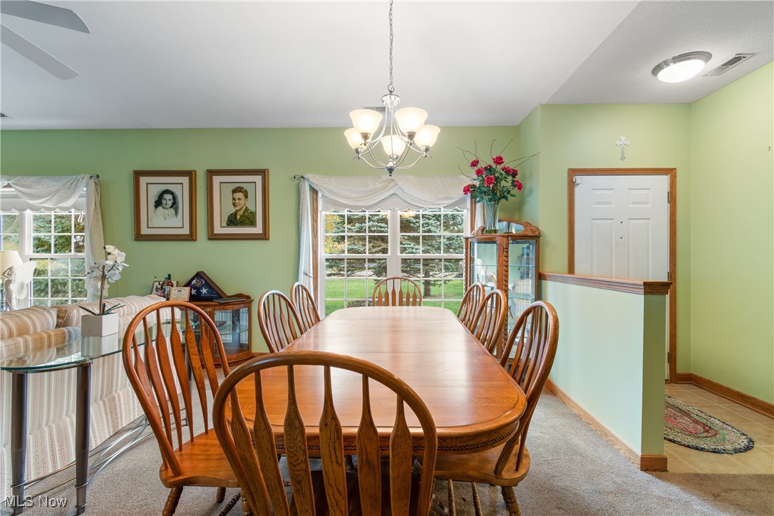 7030 Knight Avenue Northwest Canton, OH 44708 - Photo 10 of 26 Dining space featuring light carpet and ceiling fan with notable chandelier