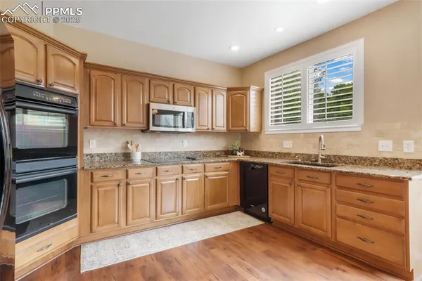 a kitchen with granite countertop stainless steel appliances stove microwave and sink
