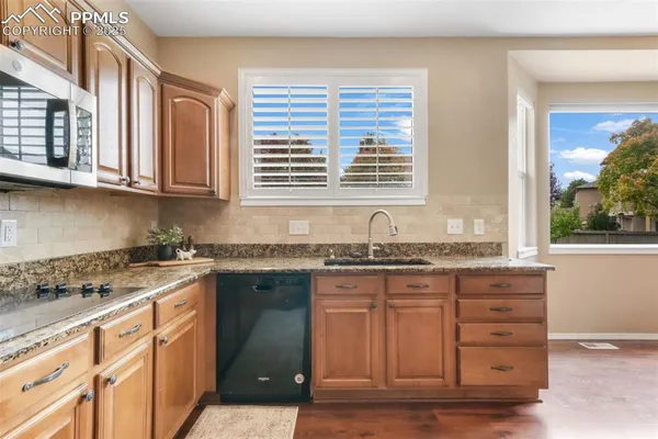a kitchen with granite countertop a sink and a stove