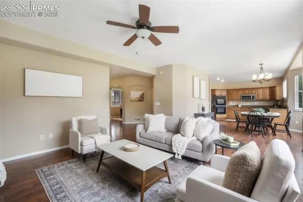 a living room with furniture and a view of kitchen