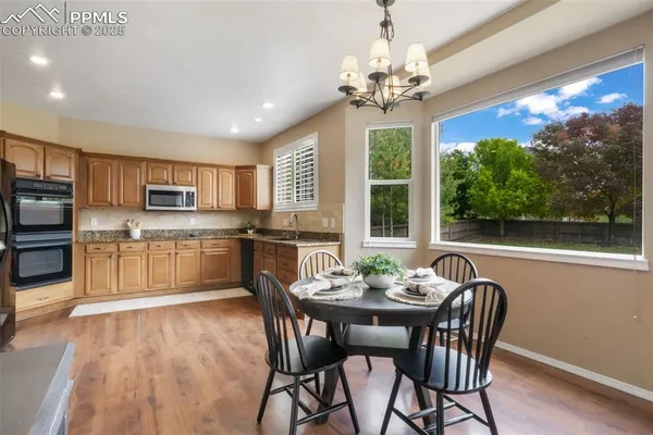 a view of a dining room with furniture wooden floor and chandelier