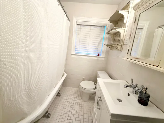a bathroom with a sink toilet and window