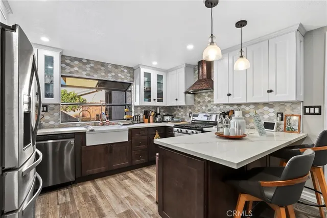 a kitchen with kitchen island granite countertop a sink cabinets and stainless steel appliances