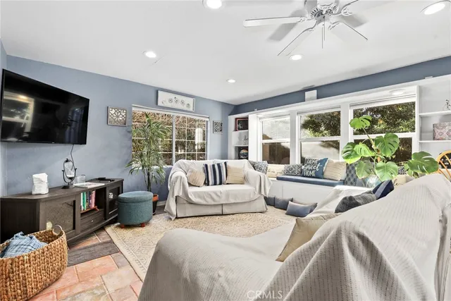 a bedroom with furniture a large window and a flat screen tv