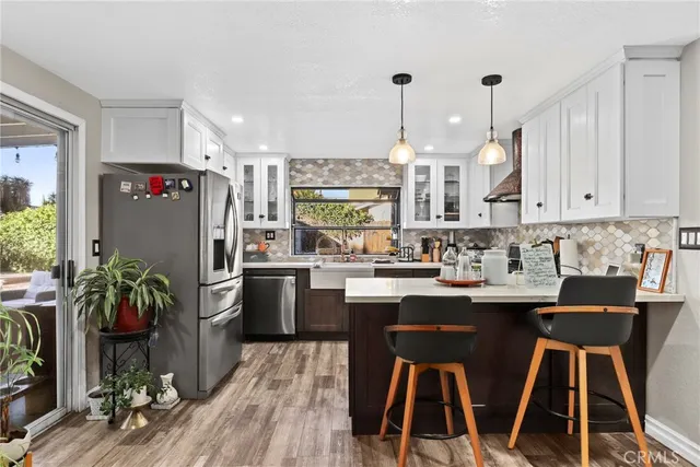 a kitchen with kitchen island a counter space a sink appliances and cabinets